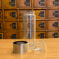 Gourde infuseur en verre, coloris gris, ouverte avec filtre inox – Herboricare